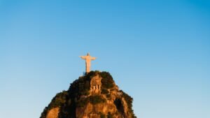 Breathtaking view of Christ the Redeemer statue atop Corcovado Mountain in Rio de Janeiro under a bright blue sky.