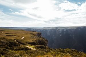 Stunning landscape of Fortaleza Canyon with expansive cliffs and lush greenery under a bright sky.
