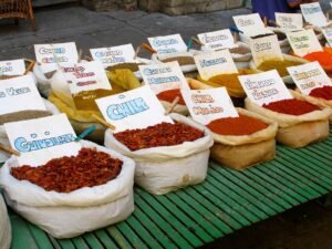 Colorful spices on display at a bustling street market in Granada, Spain.