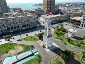 A stunning aerial view of the Clock Tower in Plaza Prat, Iquique, Chile, showcasing urban architecture and coastal beauty.