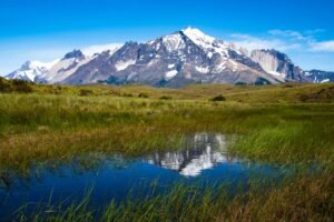 Scenic view of snowcapped Andes mountains reflecting in wetlands of Chilean Patagonia.