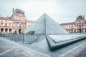 Iconic Louvre Pyramid in Paris, showcasing classic and modern architecture.