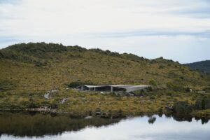 Tranquil landscape of Cradle Mountain, Tasmania, showcasing lush hills and reflective waters.