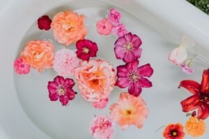 A top-down view of assorted colorful flowers floating delicately in water.