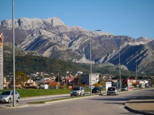 Discover the stunning landscape of Bar, Montenegro with a scenic road lined by majestic mountains.