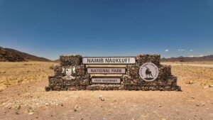 Namib-Naukluft National Park entrance sign under clear blue skies, capturing the desert landscape beauty.