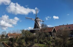 A scenic view of a traditional windmill in Hattem, Gelderland on a sunny day.