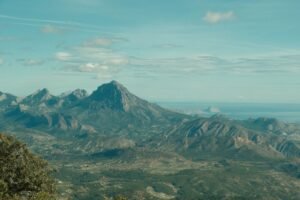 A stunning aerial view of the Puig Campana mountains in Alicante, Spain, showcasing rugged peaks and vast landscapes.