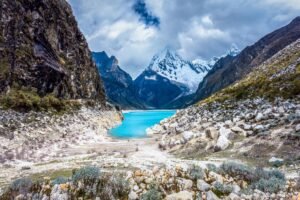 Breathtaking scenery of turquoise lake and majestic mountains in Huaraz, Peru.
