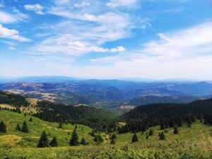 Breathtaking landscape of Kopaonik Mountain with lush green hills under a vibrant sky in Serbia.
