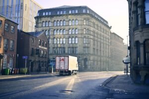 A quiet urban street scene with historic architecture in early morning light.