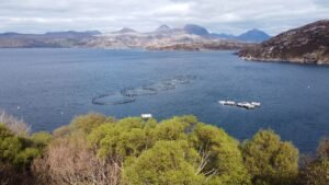 A stunning view of a loch with fish farms in the Scottish Highlands.