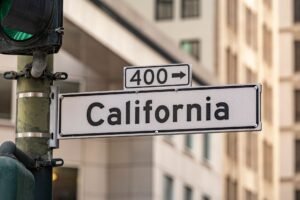 Street sign for California with traffic light in cityscape. Urban navigation and signage theme.