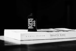 Black and white film roll on Karel Capek book against a dark background.